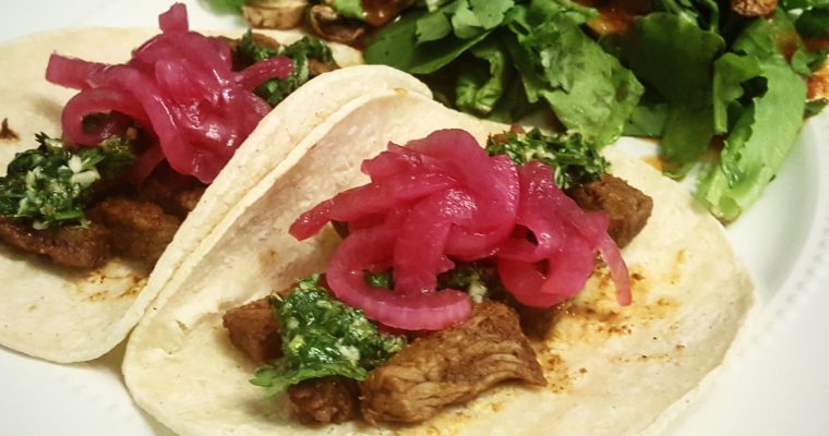 Steak tacos with chimichurri and pickled red onions