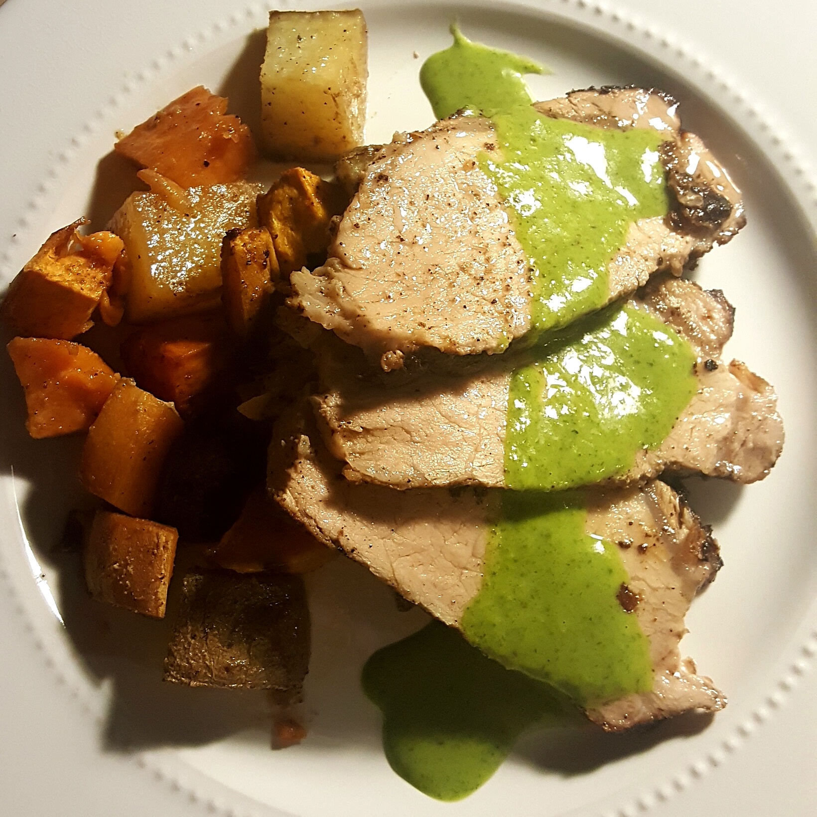 Roasted pork loin with mixed potatoes and a cilantro-radish-top sauce