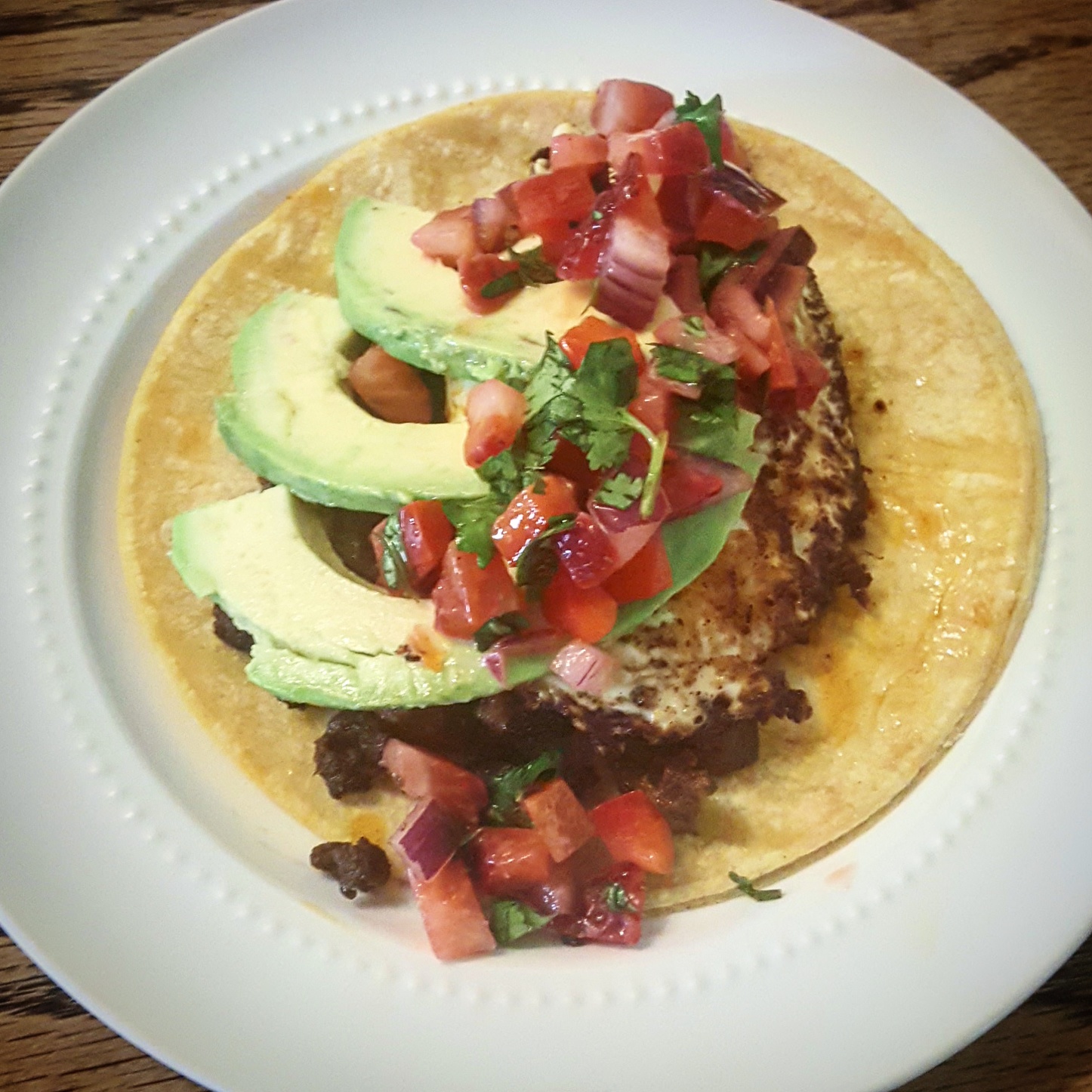 Brunch tacos with chorizo, fried egg, avocado, and strawberry pico de gallo